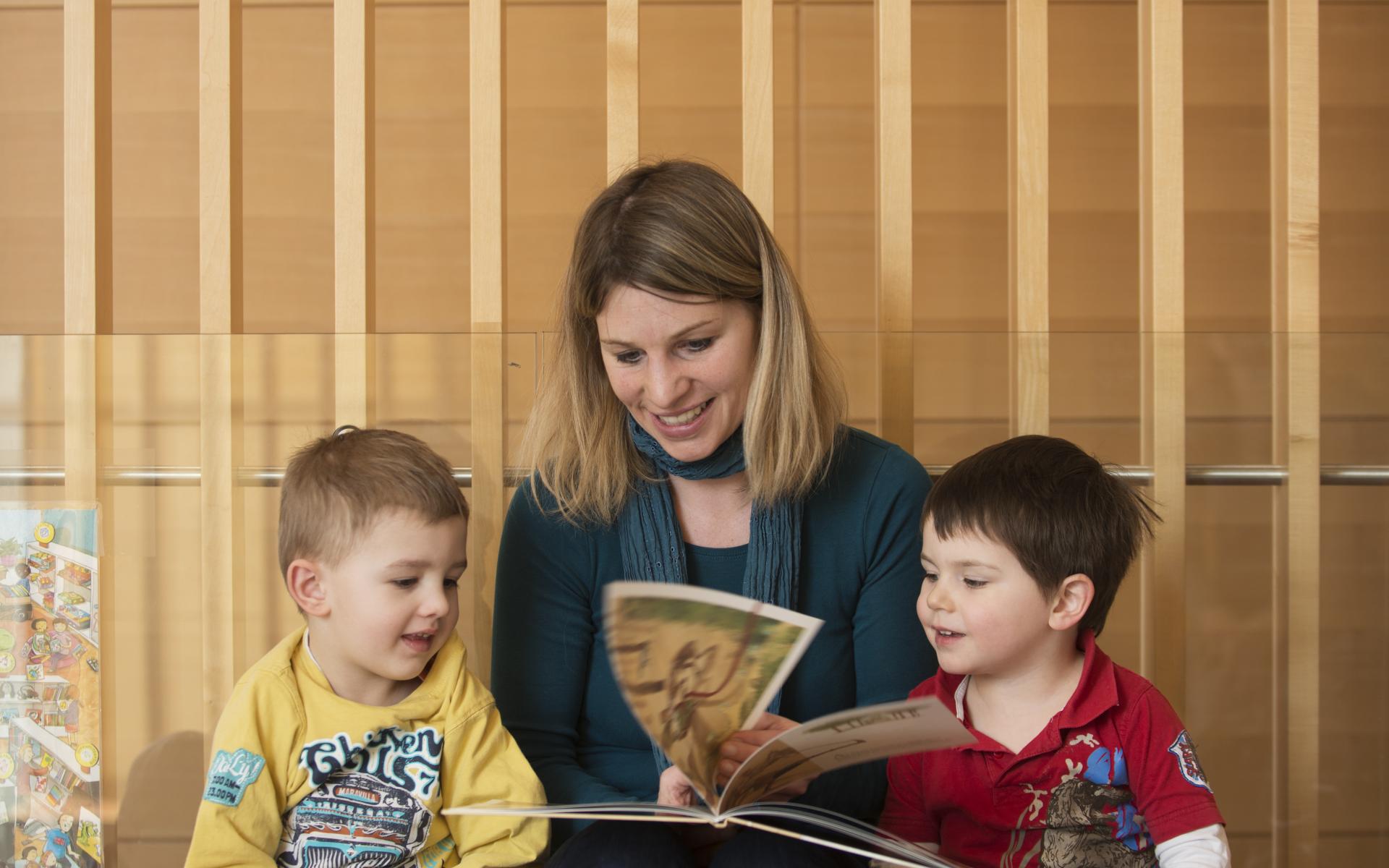 Frau liest mit Kindern